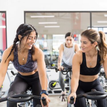 Dos chicas sobre una bici de ciclo indoor